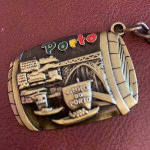 PORTO gold and tan keychain in the shape of a barrel